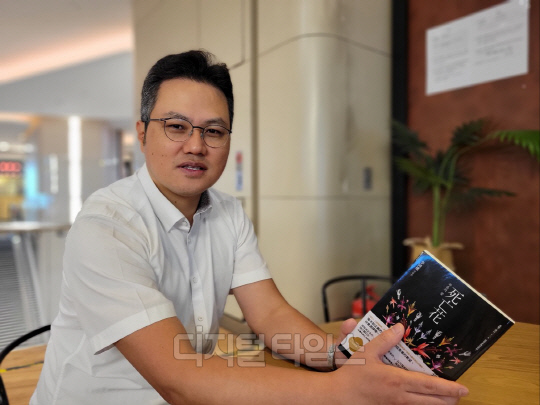 홍콩 서점에서 중국어 번체자로 출간된 도서출판 델피노의 <죽음의 꽃> 작품을 들고있는 이경재 대표.